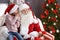 Little girl whispering in authentic Santa Claus`