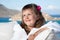 Little girl in white bathrobe relaxing on terrace