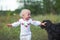 little girl in white clothes plays with black dog. Communication of children and animals. Good home dog outdoor