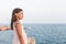 Little girl in white dress starring at the sea