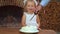 Little girl in white hat blowing out candle, number three on cake.