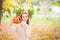 Little girl in a white sweater and jeans on a background of green textural natural background. A girl whispers in her ear a secret