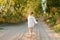 A little girl in a white traditional Ñhemise running in a scenic early autumn landscape