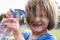 Little girl wincing as she sprays water on her face to cool off