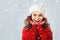 Little girl in winter clothing, think about Santa. Snow background