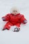 little girl in winter jumpsuit surprised in a snowdrift