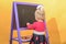 Little girl wipes the blackboard with a damp sponge. The concept of preschool education for children