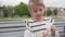 A little girl wipes her hands with a damp napkin on the street in the summer