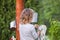 Little girl wipes her hands after the washing under the old manual washstand outdoors in countryside