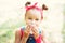 Little girl wipes her mouth with a napkin. A child with a hair tail and a red bandana