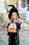 little girl in witch costume celebrate Halloween outdoor and have fun