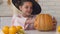 Little girl in witch costume with jack pumpkin showing thumbs-up, Halloween