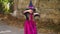 Little girl in a witch costume witch funny dances on the street..