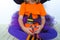 Little girl a witch suit pumpkin of which a kitten