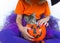 Little girl a witch suit pumpkin of which a kitten