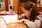 Little girl writes on the notebook of schoolwork