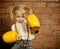 Little girl with yellow boxing gloves over brick wall