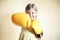 Little girl with yellow boxing gloves over yellow wall background