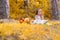 Little girl on yellow falling maple leaves background, fall outdoor.