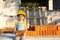 Little girl in a yellow hardhat is playing builder on the construction site of her future home. Expectation of moving, choosing a