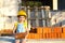 Little girl in a yellow hardhat is playing builder on the construction site of her future home. Expectation of moving, choosing a