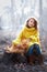 Little girl in yellow pullover and gray hat with red persian cat in the forest. Soft natural light. Cat is looking away. Girl lay