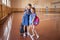 Little girls with backpacks in an empty school gym