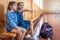 Little girls with backpacks in an empty school gym are sitting on a bench