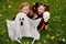 Little girls in carnival costumes of witches for halloween with a toy ghost in the park on a background of autumn