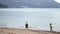 Little girls collect garbage by the sea