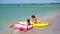 Little girls having fun at tropical beach during summer vacation playing together