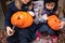 Little girls make jack-o-lantern from big pumpkins for celebratiion of halloween holiday.Witch costume, hat, coat. Cut