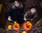 Little girls make jack-o-lantern from big pumpkins for celebratiion of halloween holiday.Witch costume, hat, coat. Cut with knife,