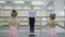 Little girls are practice with teacher in ballet school indoors.