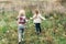 Little girls running through a meadow. Adorable sisters having fun on a nature. Two little girlfriends. Happy and healthy