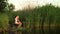 Little girls sitting with fishing rod on river bank