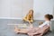 Little girls sitting on the floor, playing in a giant handmade cardboard domino