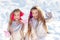 Little girls throw snowball in park. Portrait of two little girls play with snow in winter. Cute sisters playing in a