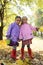 Little girls in waterproof coats and boots in autumn park