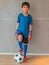 Little goalkeeper boy is standing on soccer football portrait