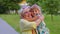 Little granddaughter child embracing kissing with her grandmother in park, happy family relationship