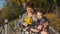 Little granddaughter hugs beloved grandmother with a bouquet of yellow leaves in her hands.