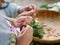 Little granddaughter`s hands learning to prepare vegetables for cooking by imitating / doing the same as shown by her grandma