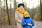 Little grandson and elderly grandmother during walking in autumn park. Friendship granny and grandchild