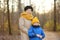 Little grandson and elderly grandmother during walking in autumn park. Friendship granny and grandchild