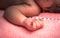 A little hand of newborn baby with light at postpartum care unit in hospital when she sleeping with her mother, so cute.