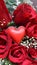 Little handmade valentines red heart in fresh red rose bouquet