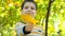 Little handsome boy holding a yellow maple leaf. Warm Colorful Autumn.