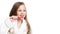 Little happy beautiful preschooler girl brushes her teeth with a pink toothbrush smiling looking to the side on a white background