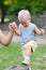 Little happy boy climbing wooden pillar on outdoor playground